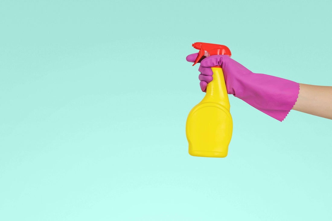 Holding a cleaning spray with pink marigolds