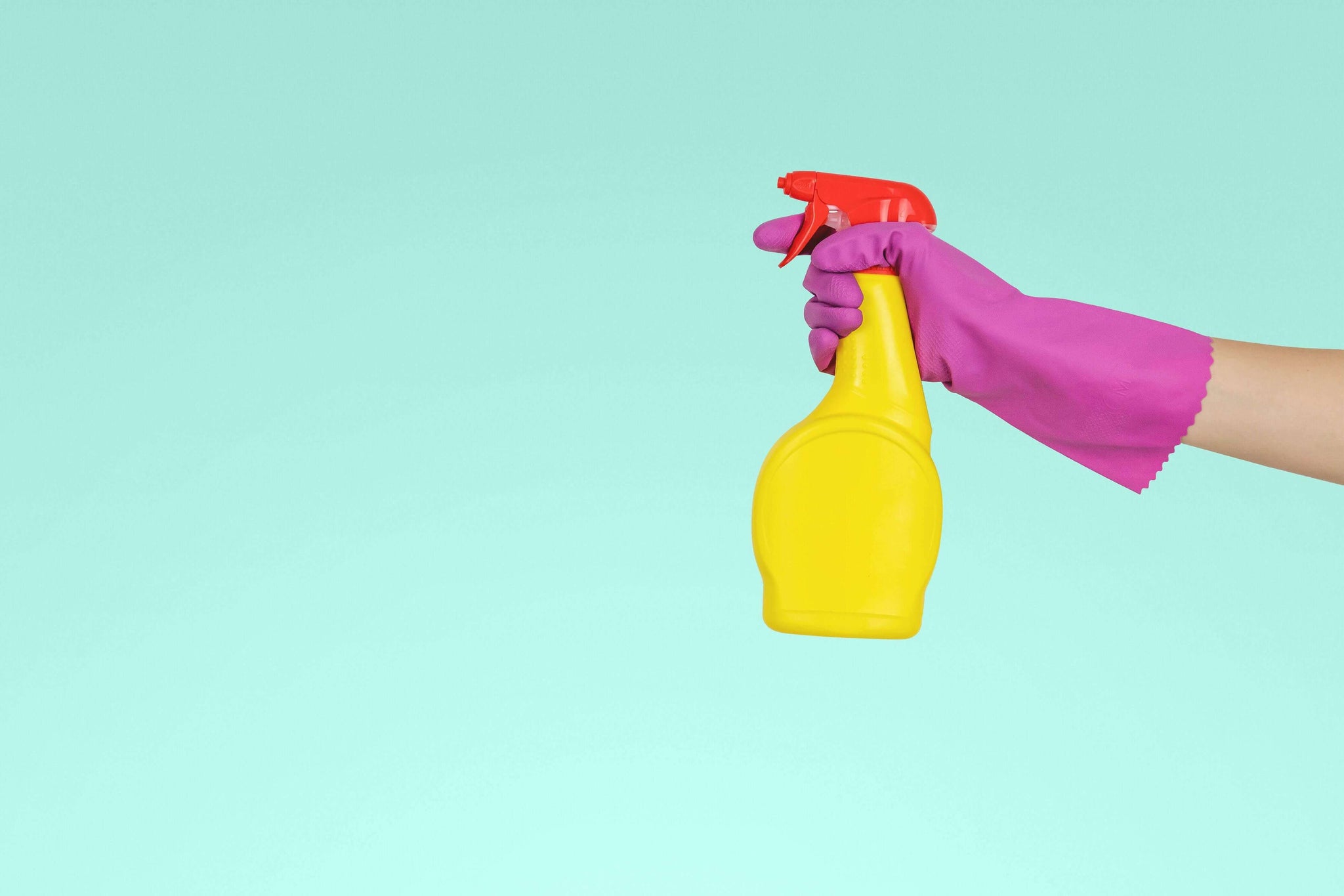 Holding a cleaning spray with pink marigolds